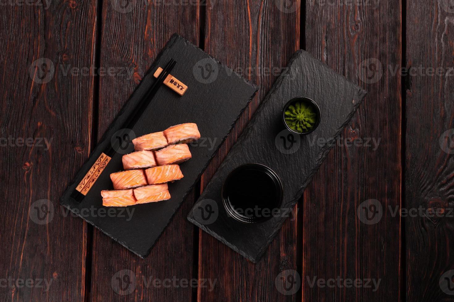 Sushi roll philadelphia with crab and cucumber and cream cheese, caviar on black background top view. Sushi menu. Japanese food concept photo