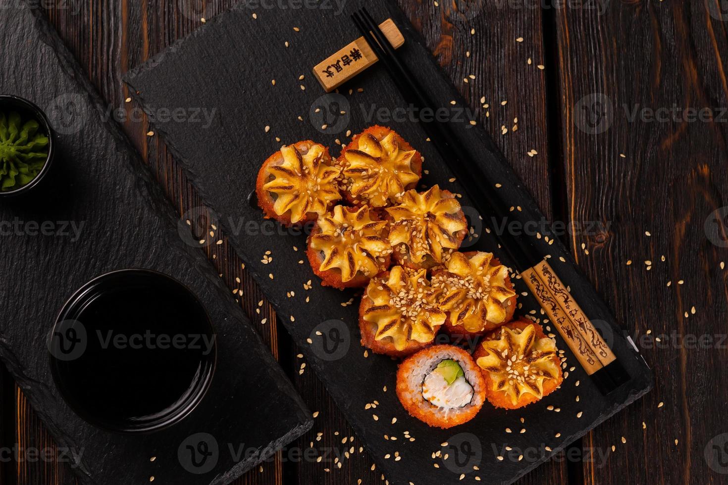 California sushi roll with crab, avocado and tobiko caviar served on black board top view close-up - Japanese asian food photo