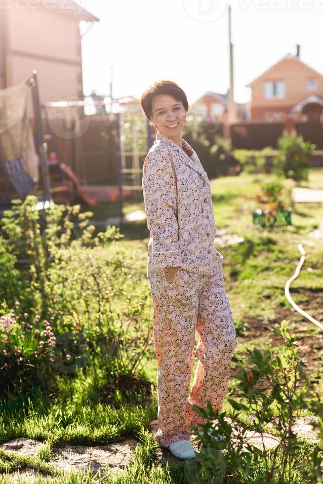 Cheerful woman in home wear pajama summer outdoor backyard in home - sleepwear and homewear concept photo