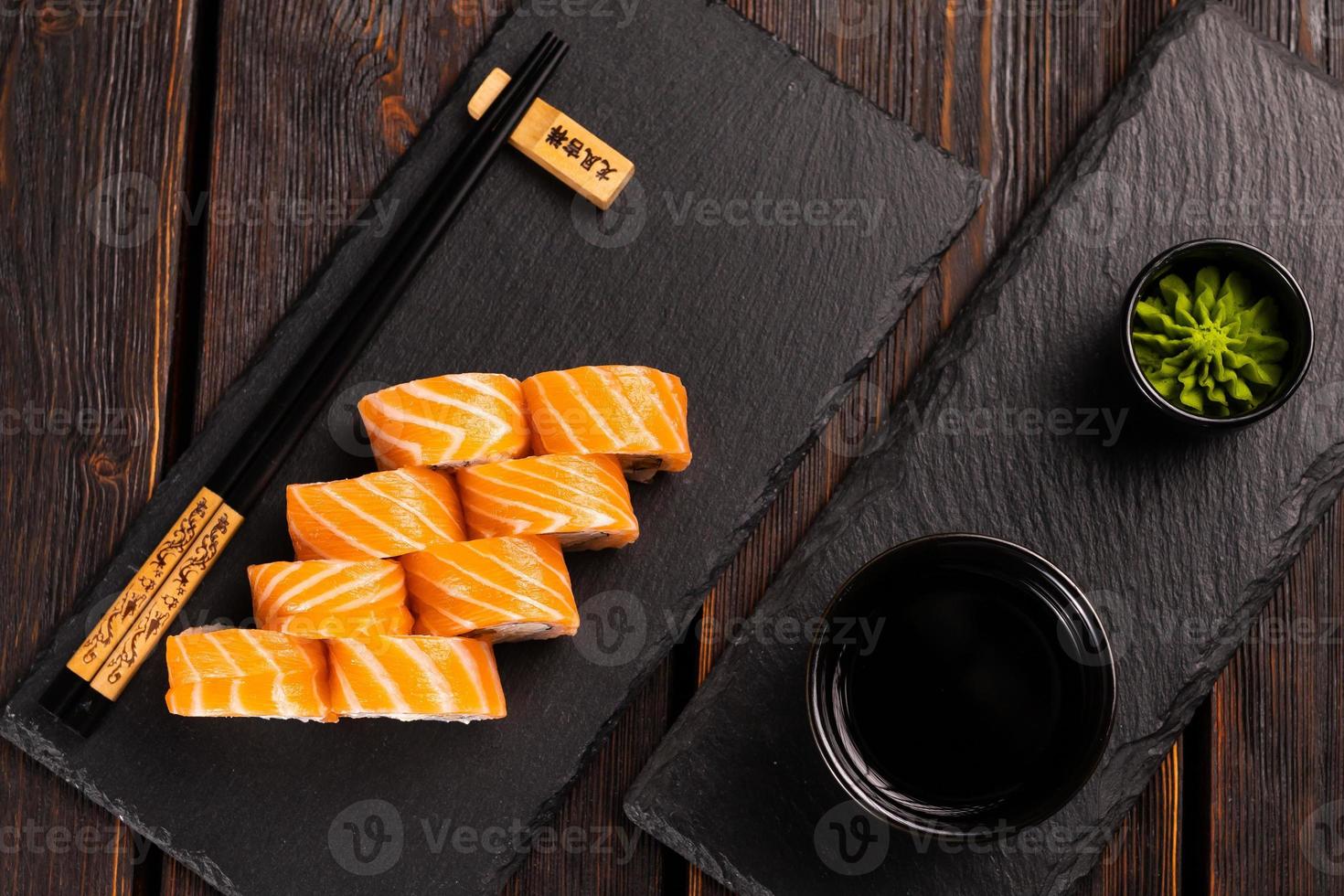 Sushi roll philadelphia with salmon and cucumber and cream cheese on black background. Sushi menu. Japanese food concept top view photo