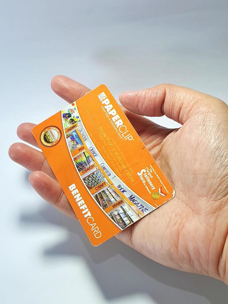 West Java, Indonesia on July 2022. Isolated photo of a hand holding a loyalty card, Benefit Card Paperclip.