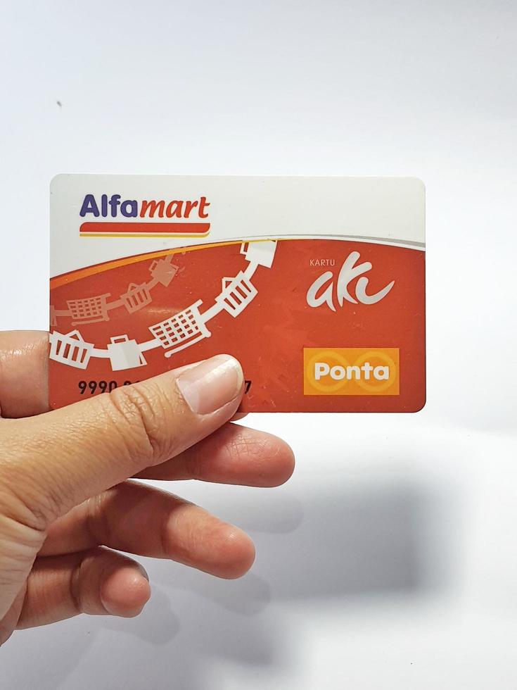 West Java, Indonesia on July 2022. Isolated photo of a hand holding a loyalty card, Alfa Gift Card.