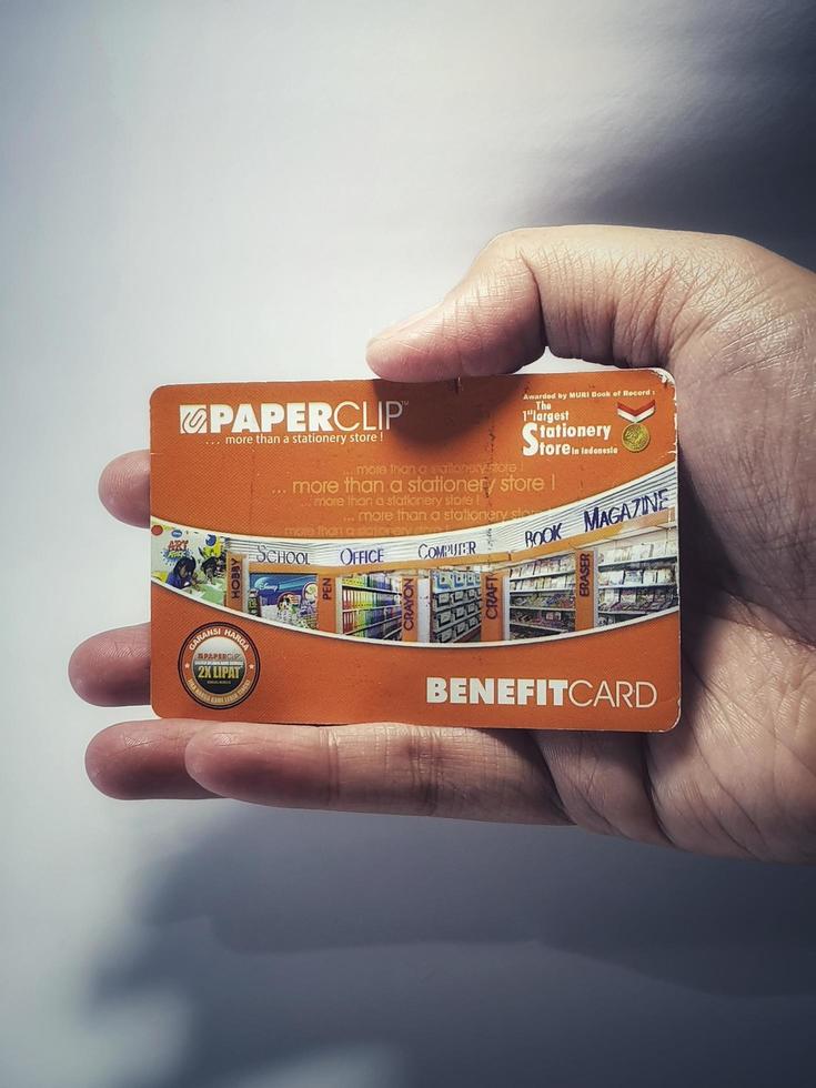 West Java, Indonesia on July 2022. Isolated photo of a hand holding a loyalty card, Benefit Card Paperclip.