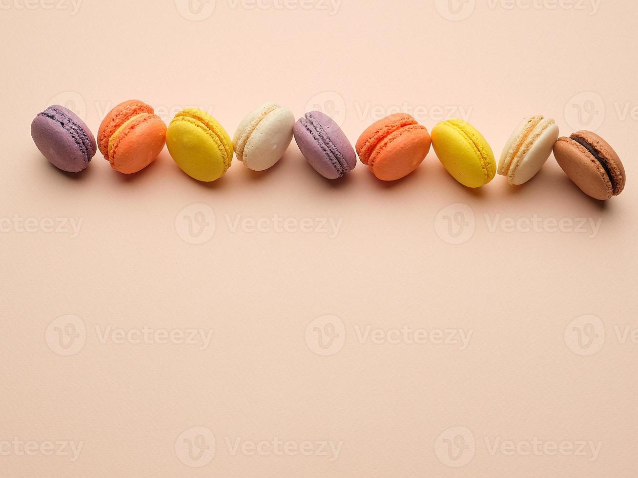 round multi-colored baked macarons with cream lie in a line photo