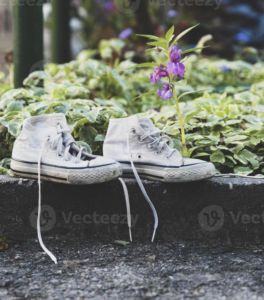 old worn white textile shoes with untied laces photo