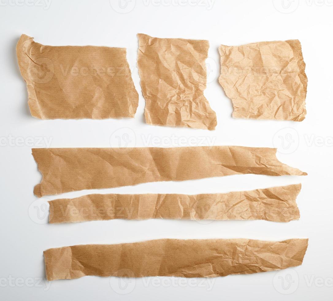 torn brown pieces of parchment paper on a white background photo