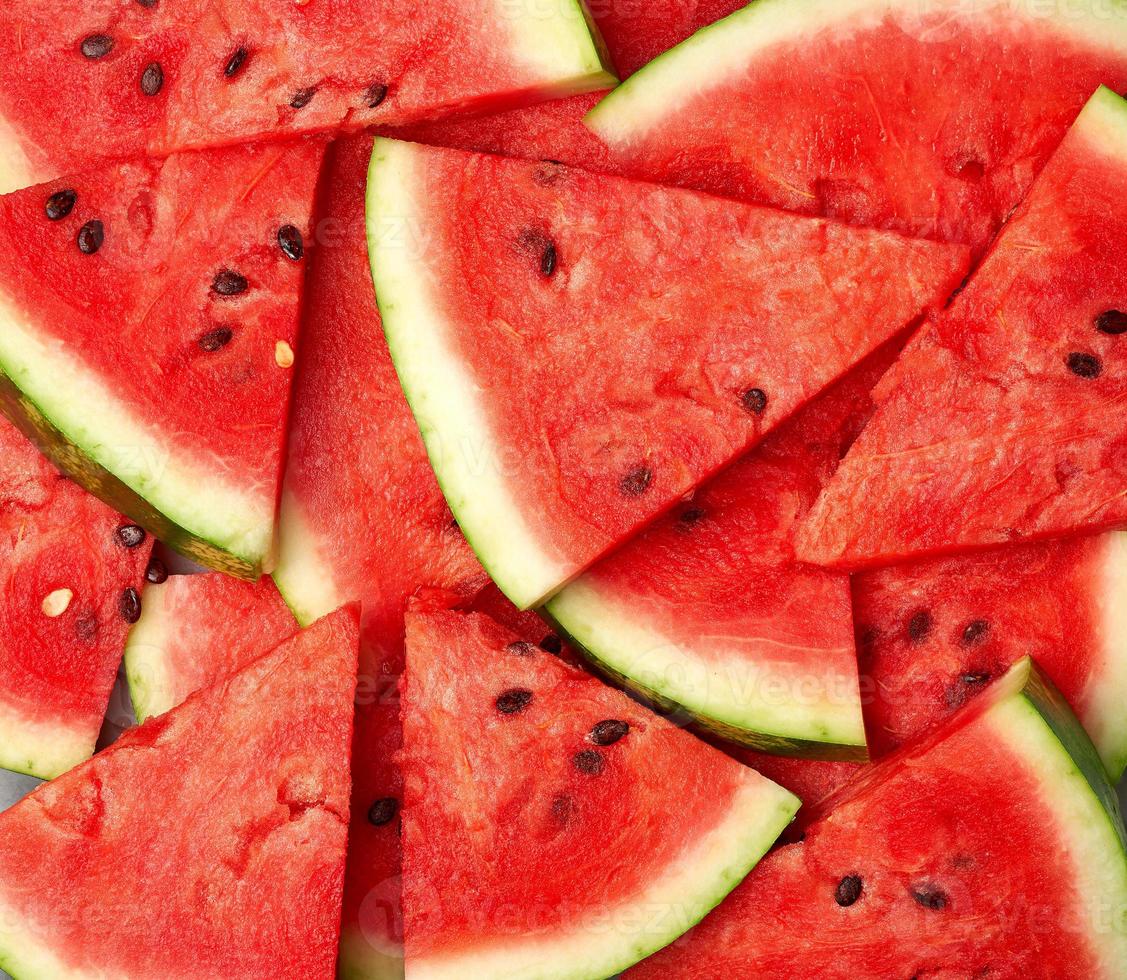sliced triangular slices of ripe red watermelon with seeds photo