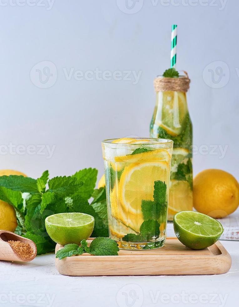 summer refreshing drink lemonade with lemons, mint leaves, lime in a glass photo