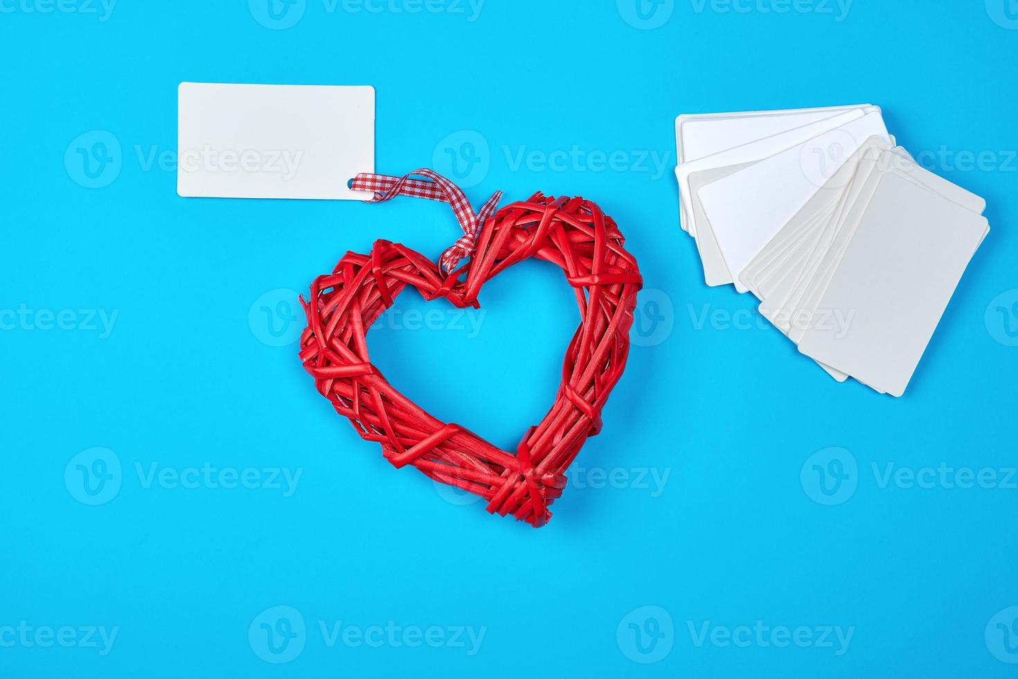 corazón rojo de mimbre de madera y tarjetas de visita de papel blanco vacías foto