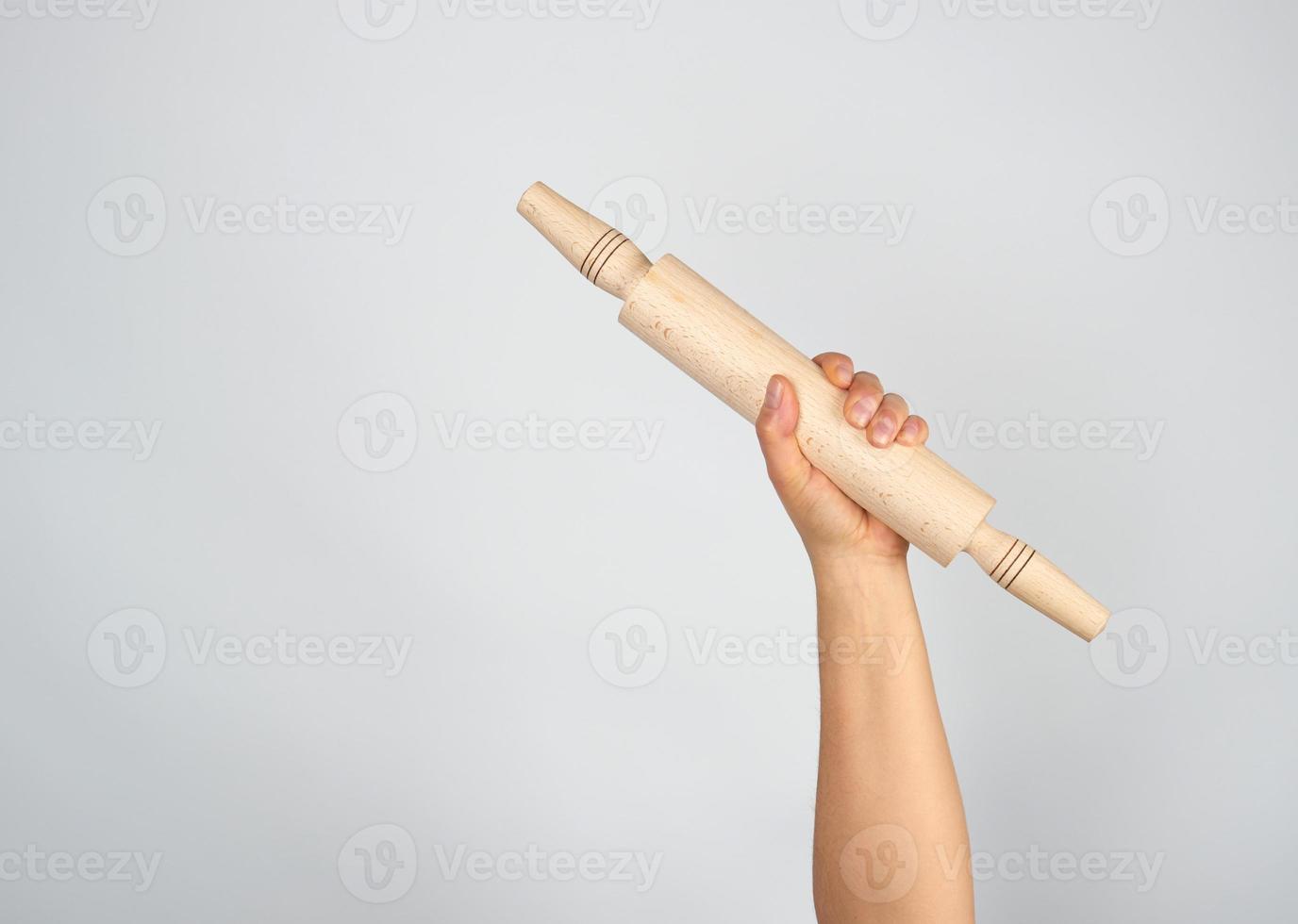 hand holding a wooden rolling pin photo