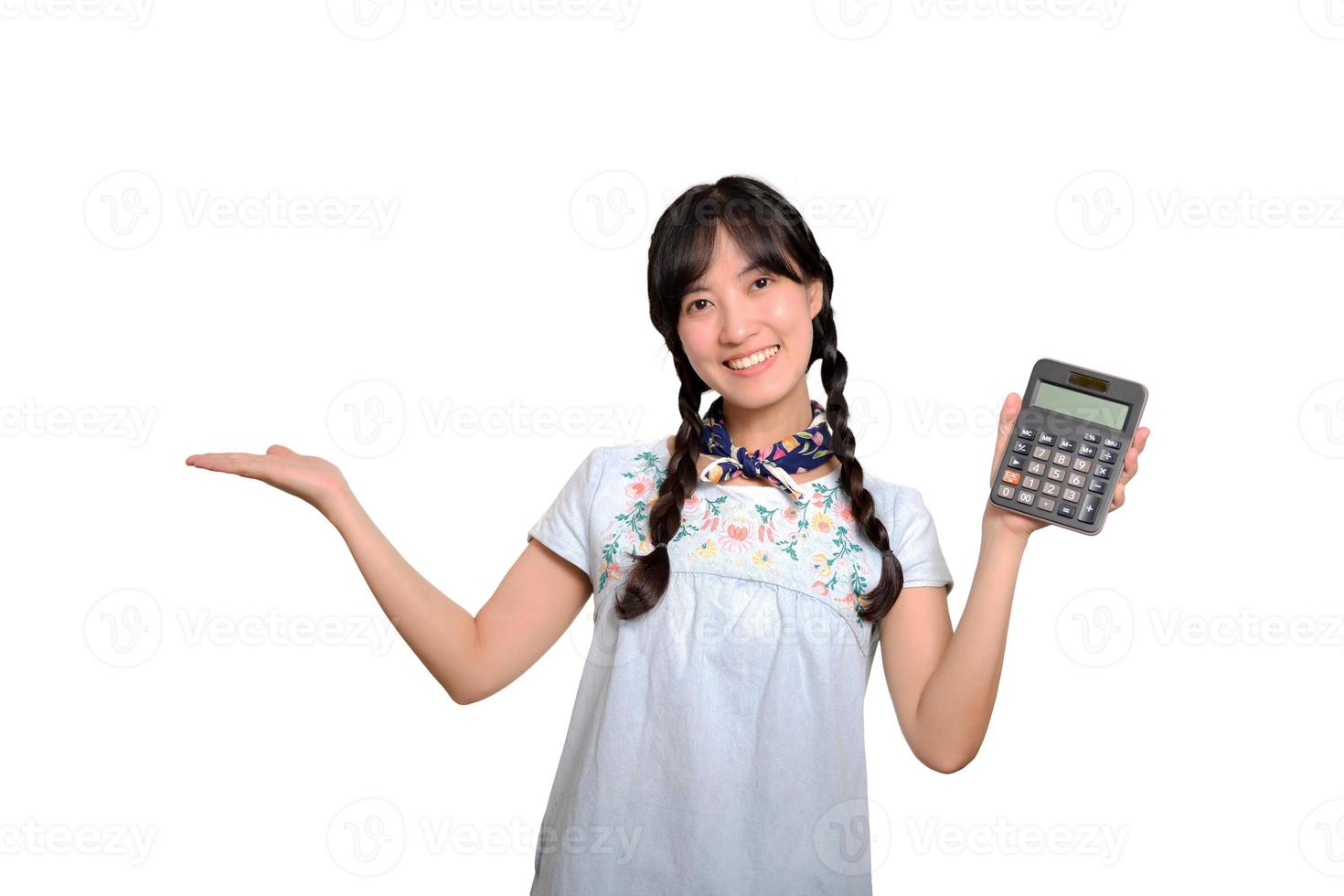 retrato de una hermosa joven asiática vestida de mezclilla sosteniendo una calculadora de fondo blanco. concepto de compras en línea de negocios. foto