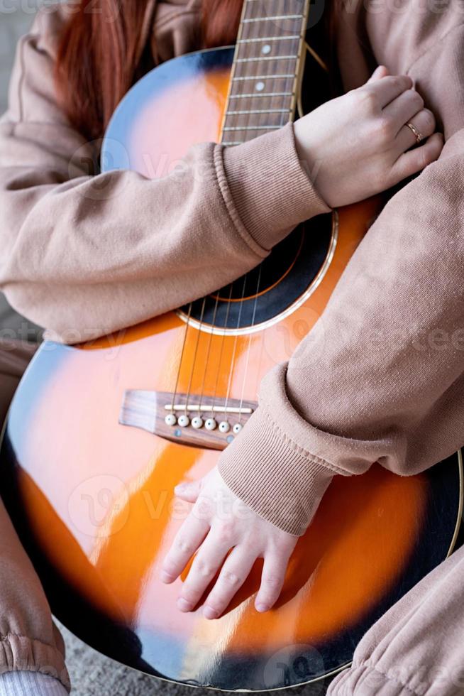 Young woman playing guitar at home photo