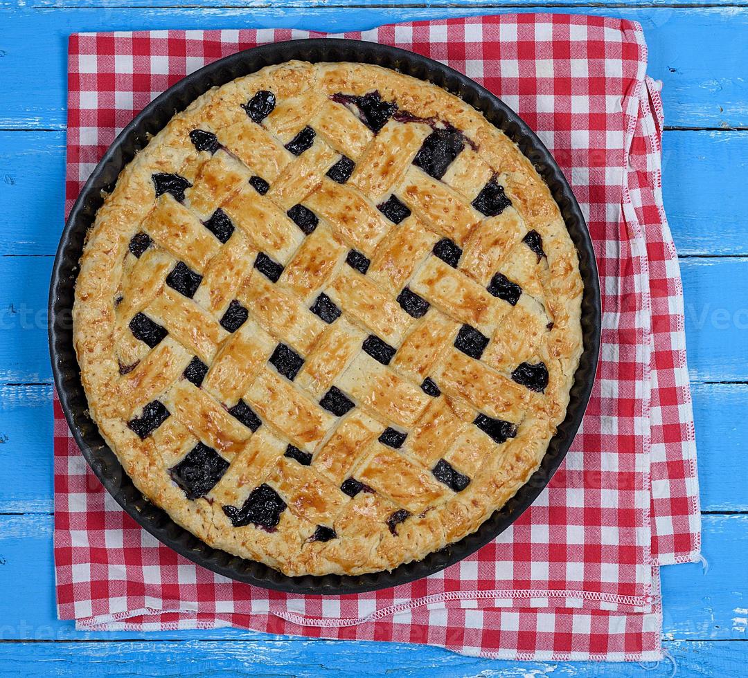 baked round black currant cake on an iron plate photo