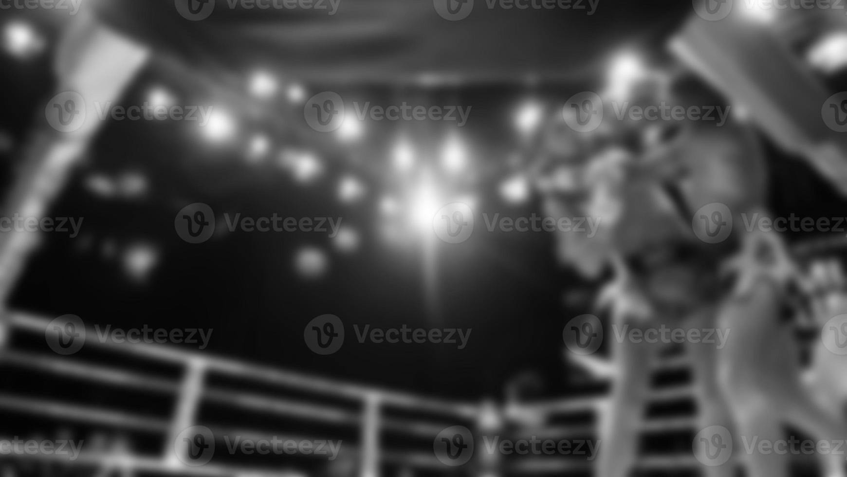 Blurred images black and white photo style of Thai boxing or Muay Thai or Kickboxing which local and foriegn boxer are fighting on the ring at indoor stage as martial art sport. Muay Thai Kick boxing