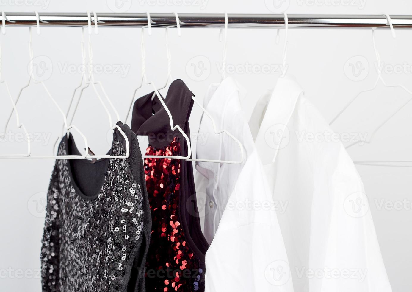 black women's blouse with red sequins, white men's shirts hang on a white iron hanger photo