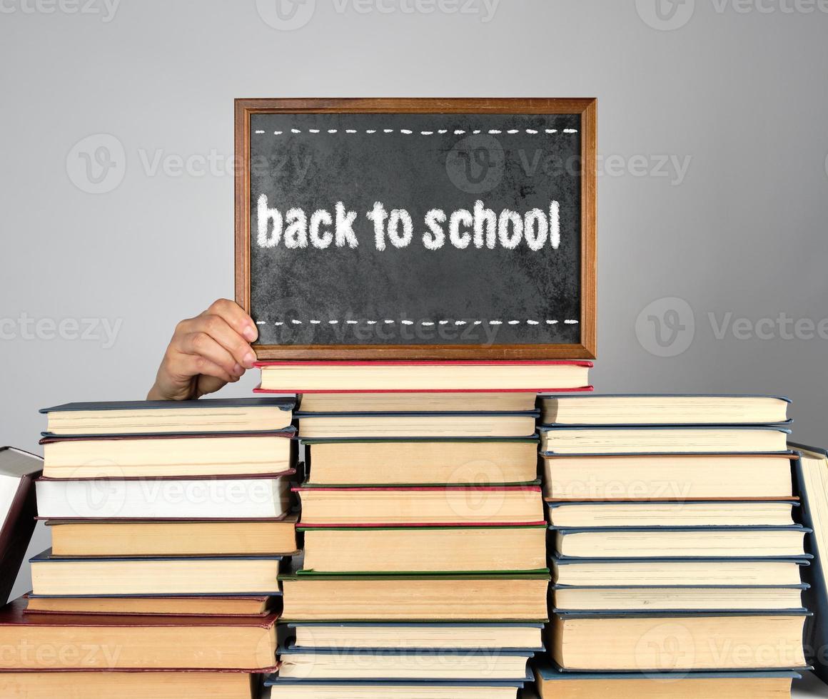 stack of various hardcover books and wooden brown chalk frame photo