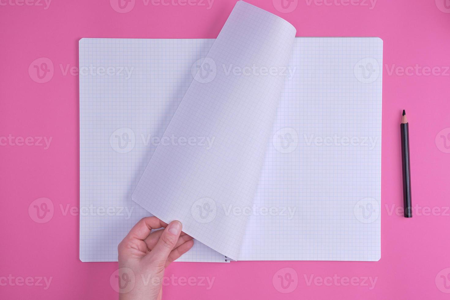 empty open notebook in a cell and a female hand photo
