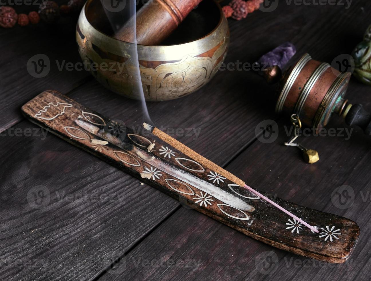 incense stick burning on a wooden stand photo