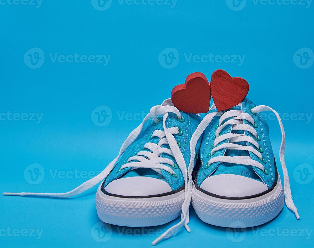 pair of blue textile sneakers with white untied laces photo