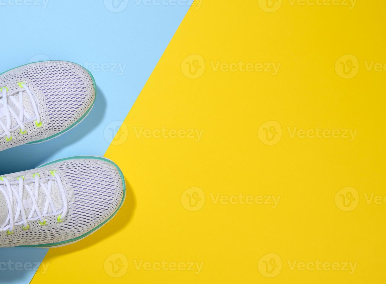 white women's sneakers with laces on a blue yellow background photo