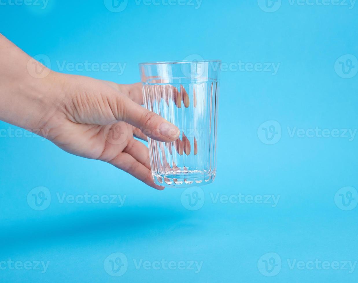 woman's hand holding an empty transparent glass photo