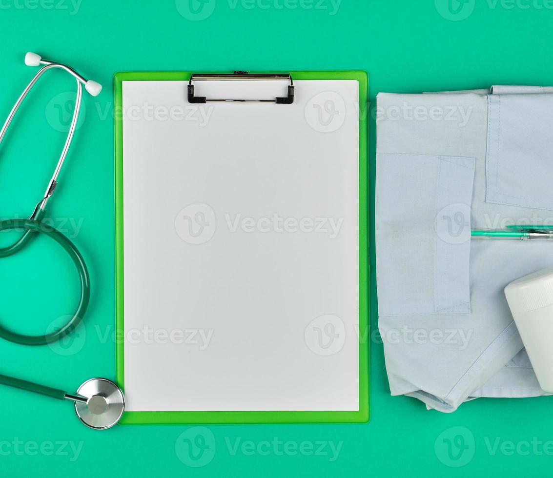 empty white sheets and a medical stethoscope on a green background photo