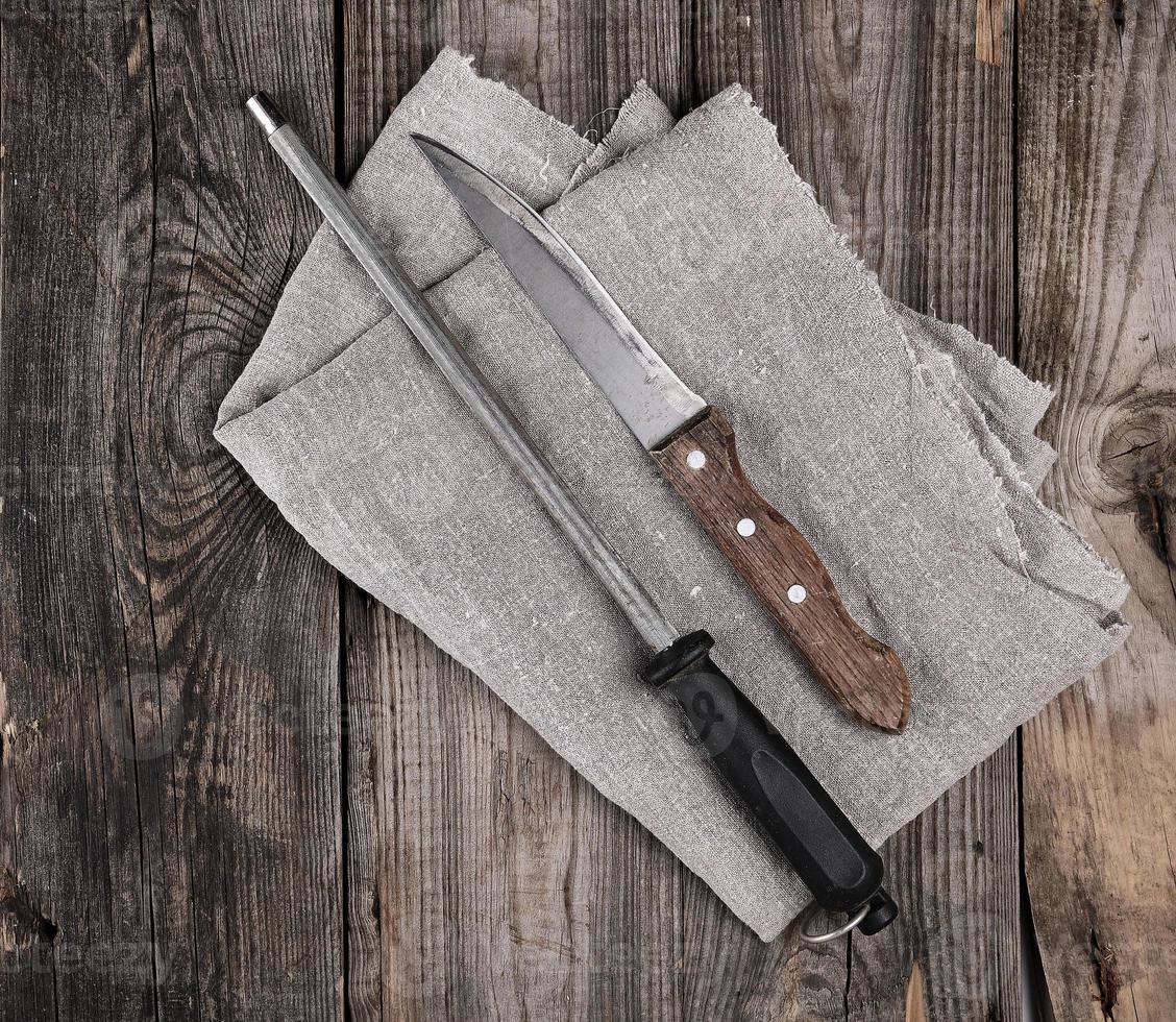 cuchillo con afilado en la mesa de madera foto