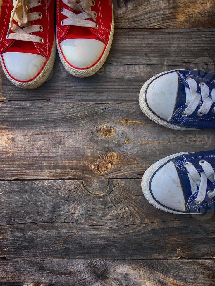 Two pairs of textile shoe on a gray wooden surface photo