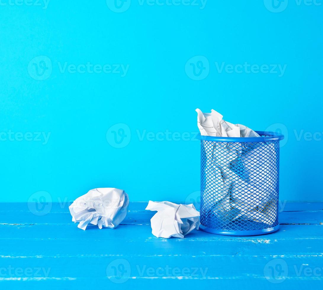 blue metal bucket filled with crumpled white paper photo