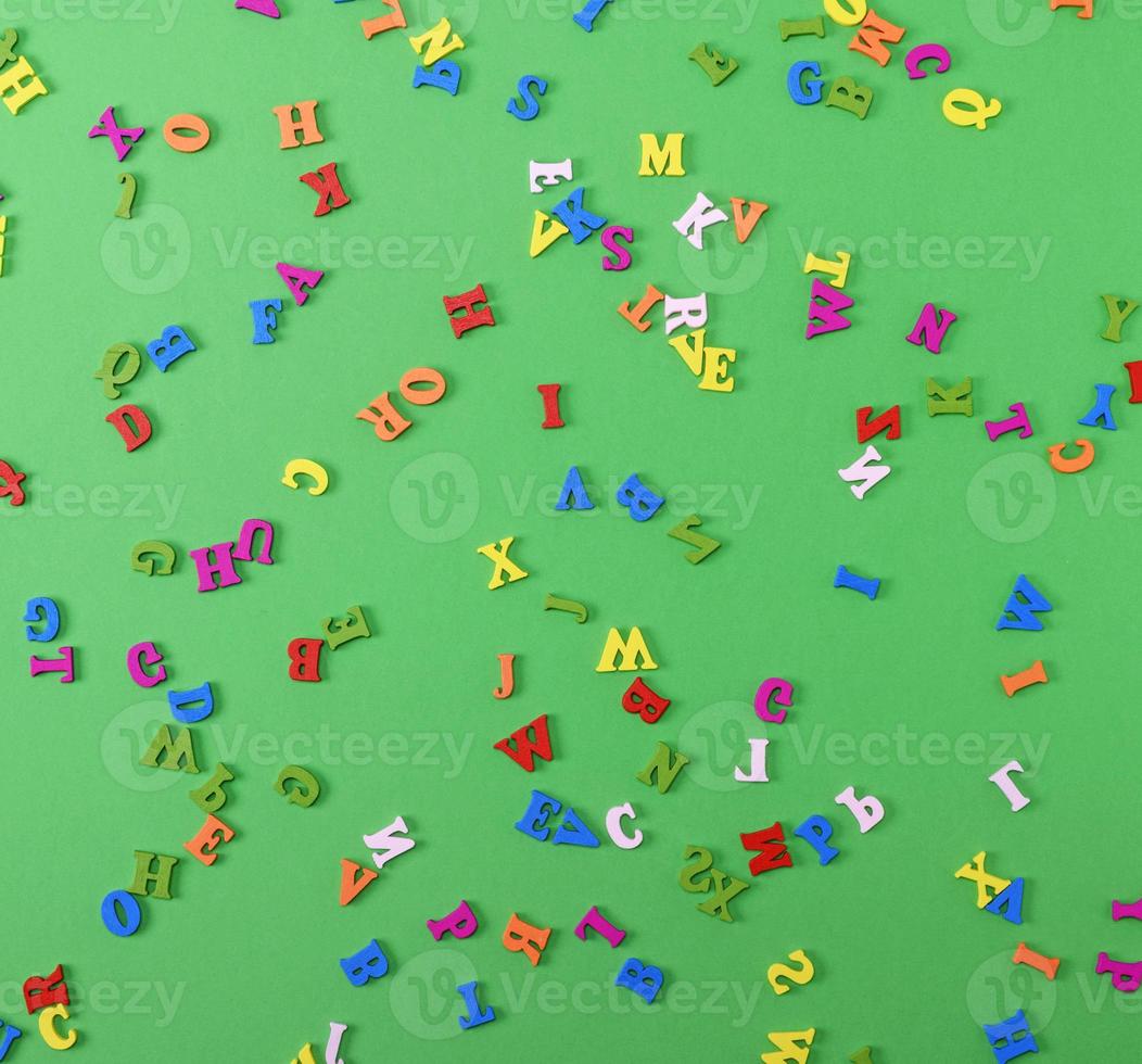 small wooden multi-colored letters of the English alphabet are scattered photo