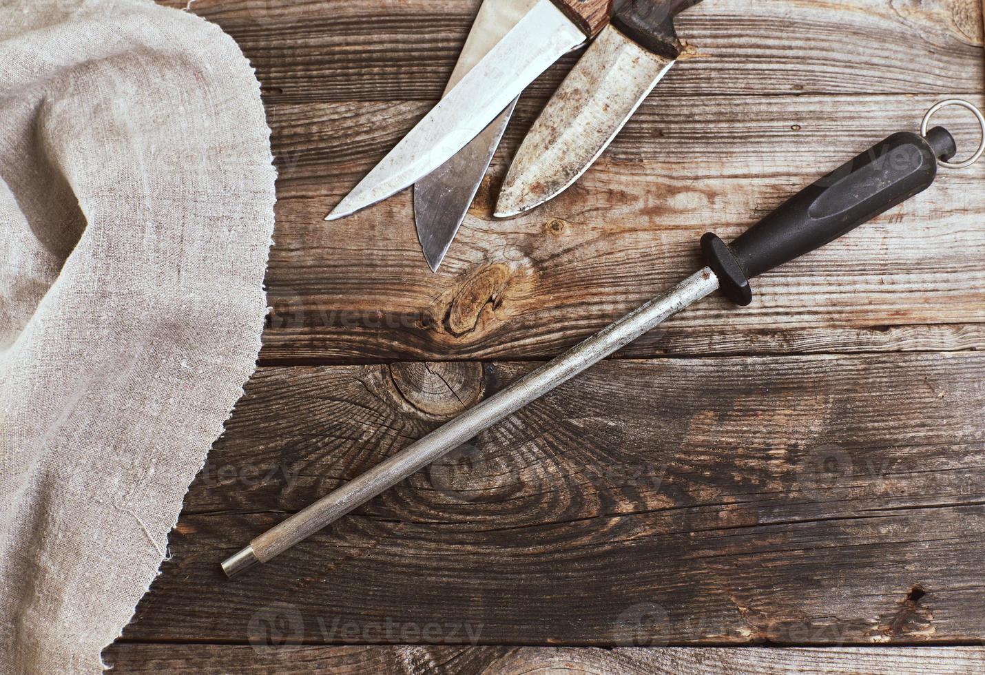 cuchillo con afilado en la mesa de madera foto