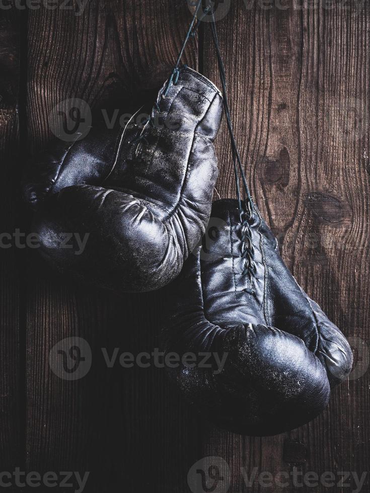 ,  black leather boxing gloves hanging on a nail photo