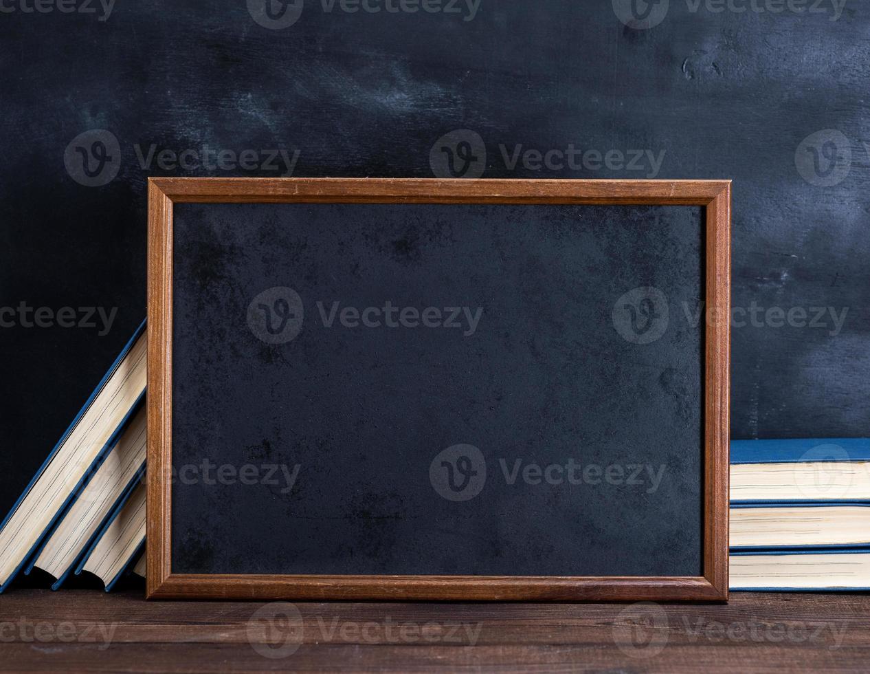 empty black chalk drawing frame and stack of books photo