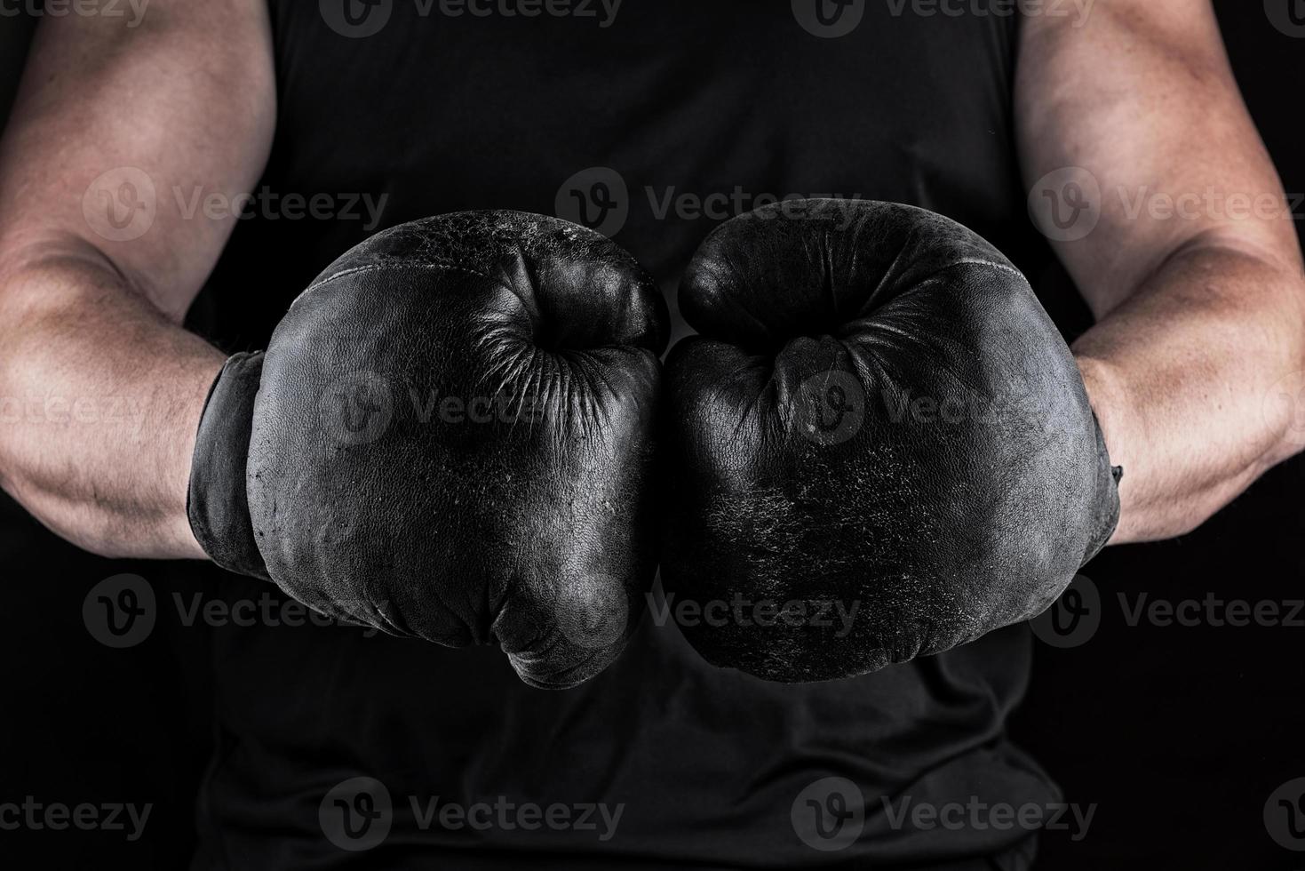 hands of an athlete in black old sport boxing gloves photo