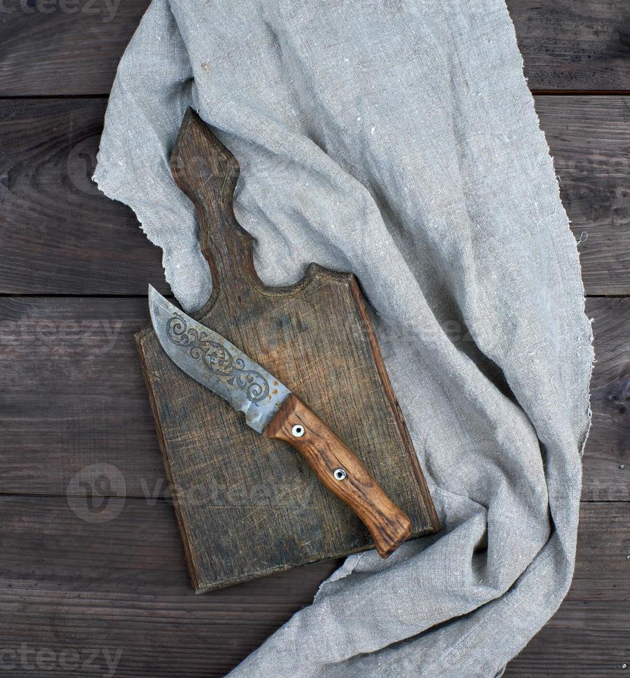 old wooden kitchen board and vintage knife photo