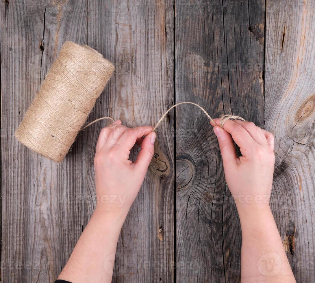 female hands holding a brown rope photo