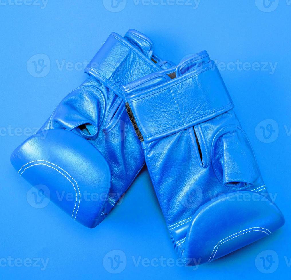 blue sport leather boxing gloves on a red background photo