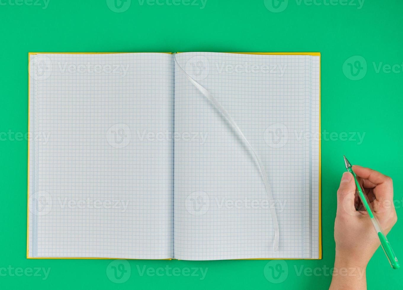 empty open notebook in a cell and female hand photo