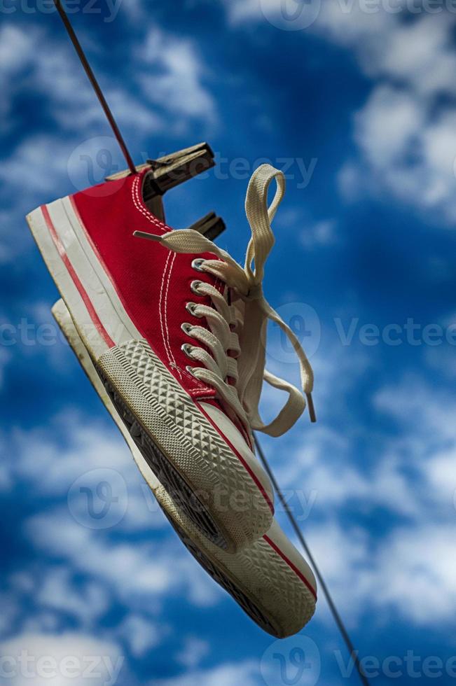 pair of red sneakers on clothesline photo