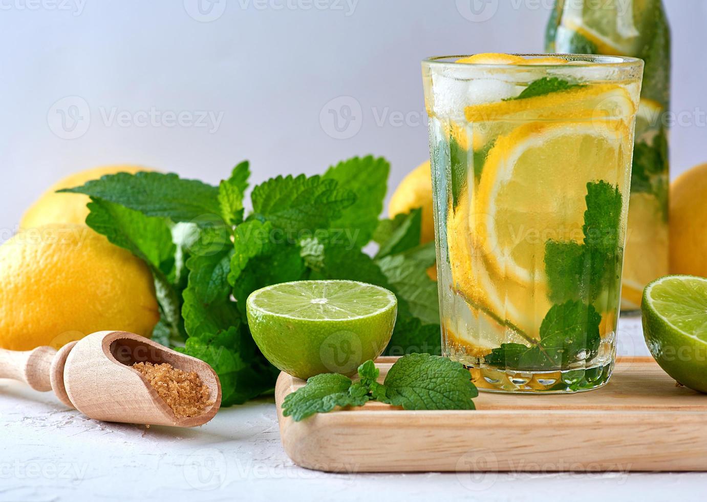 summer refreshing drink lemonade with lemons, mint leaves, lime in a glass photo