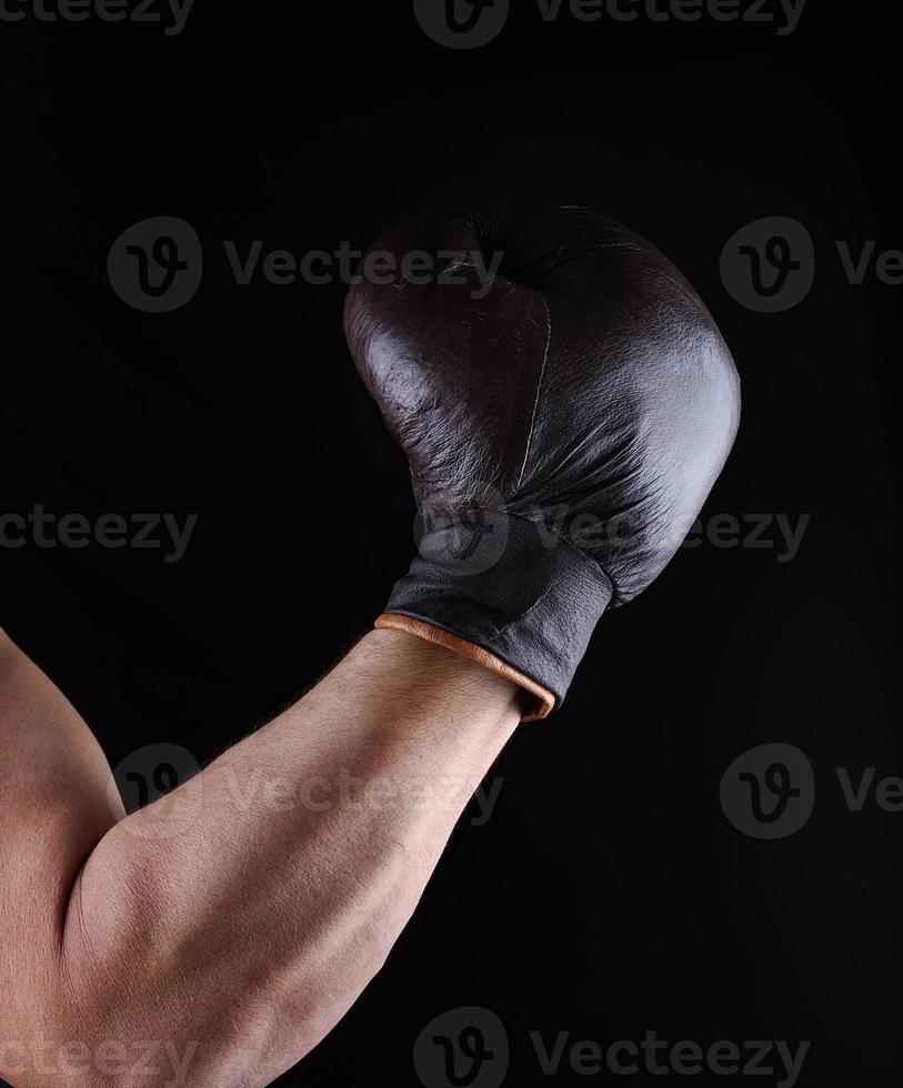 man's hand is wearing a brown leather boxing glove photo