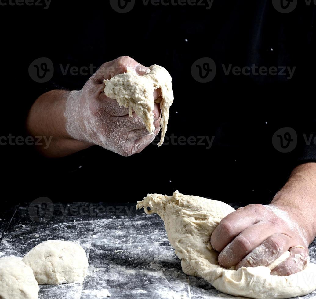 male hands substitute white wheat flour dough photo