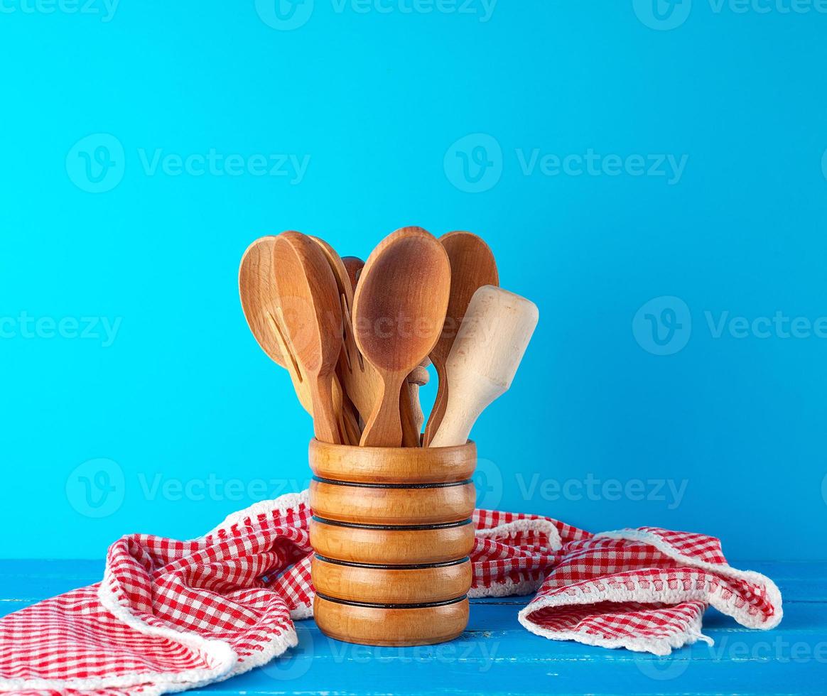 wooden spoons in a wooden container on a blue table photo