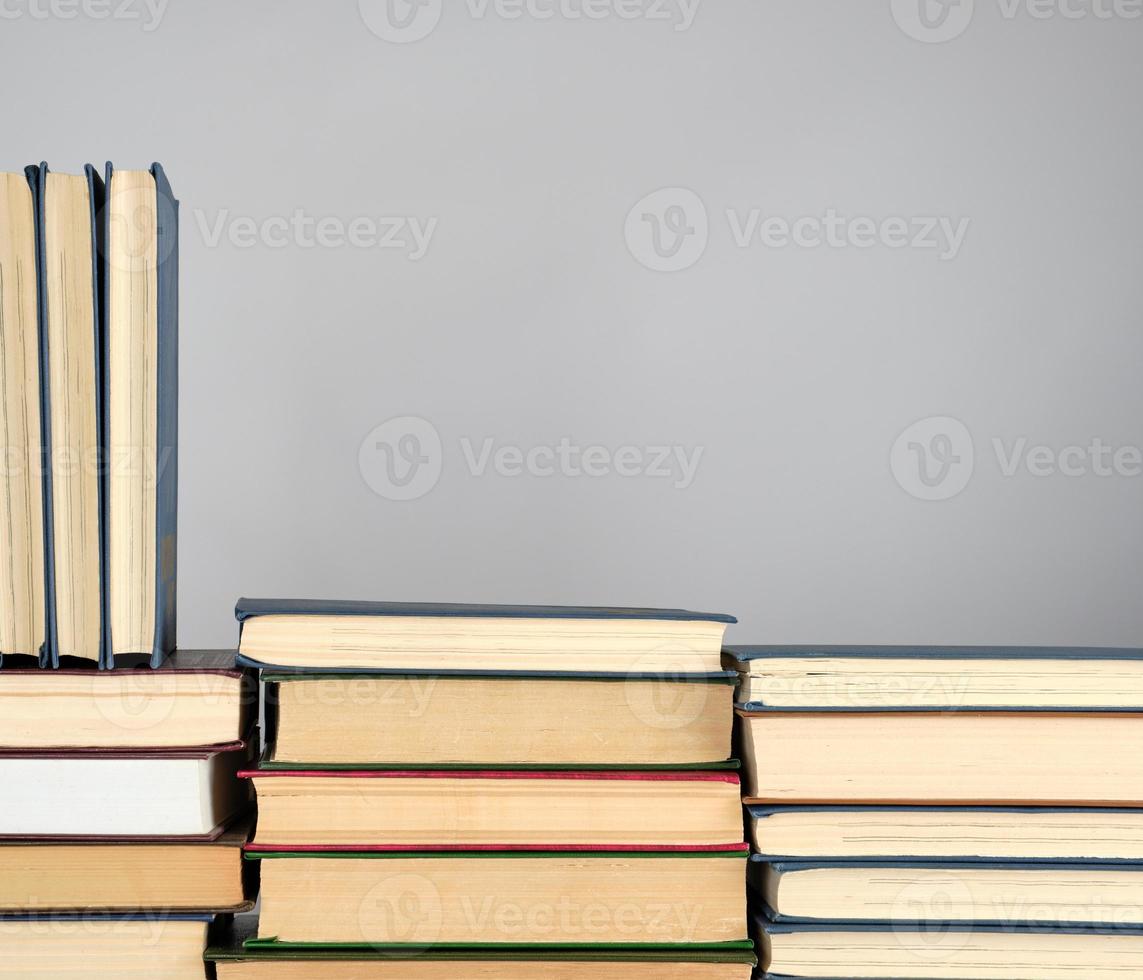 stack of different books on a gray background photo