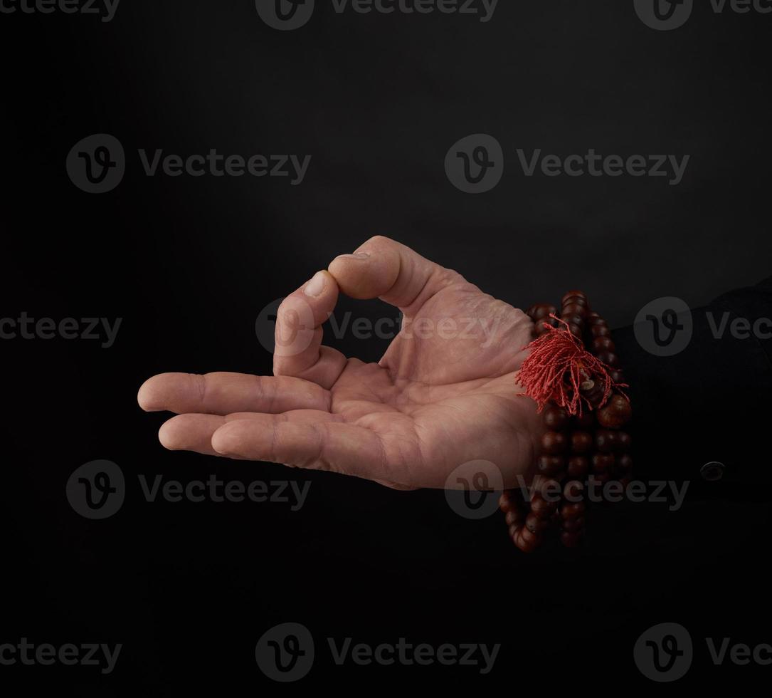 male hand shows the mudra of Knowledge on a black background photo