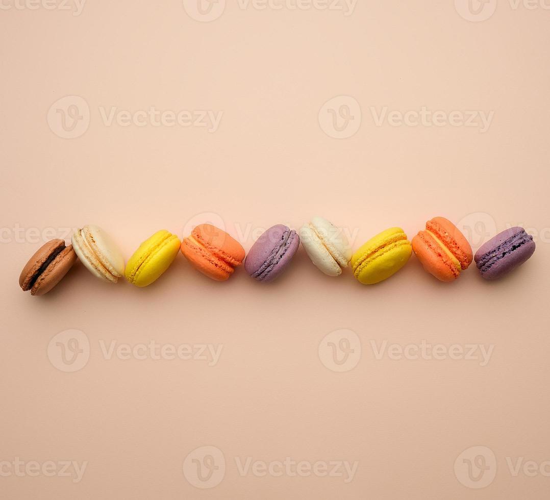 round multi-colored baked macarons with cream lie in a line photo