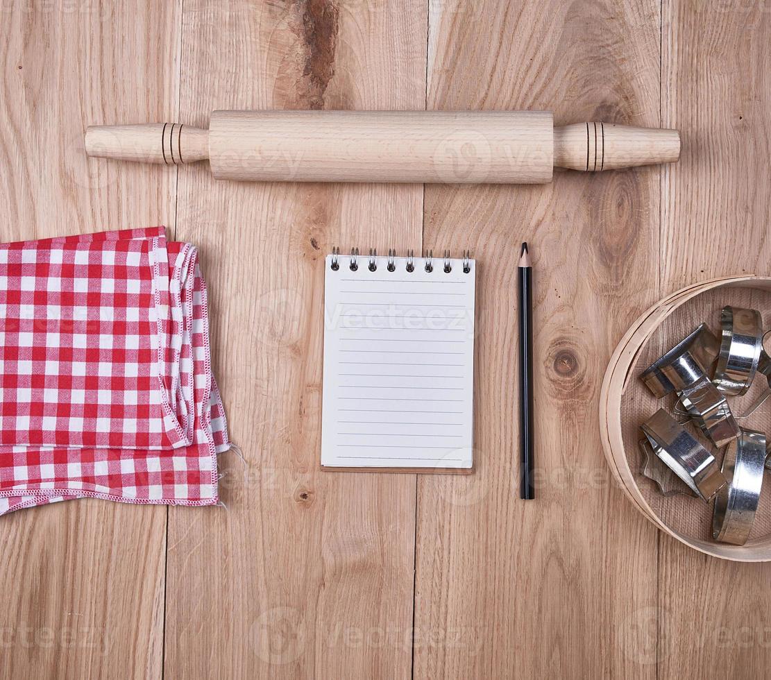 cuaderno abierto en una celda, tamiz redondo de madera foto