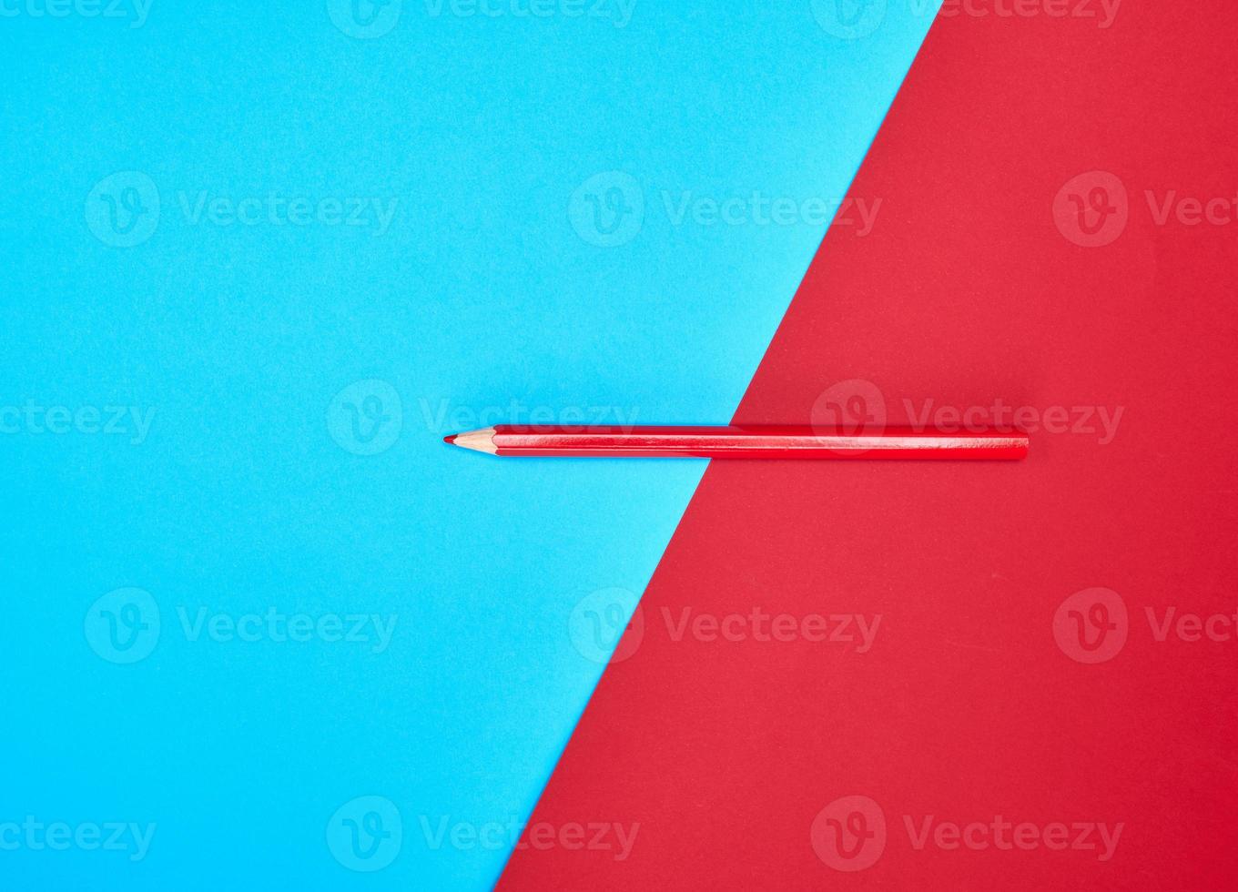 red wooden pencil on color abstract background photo