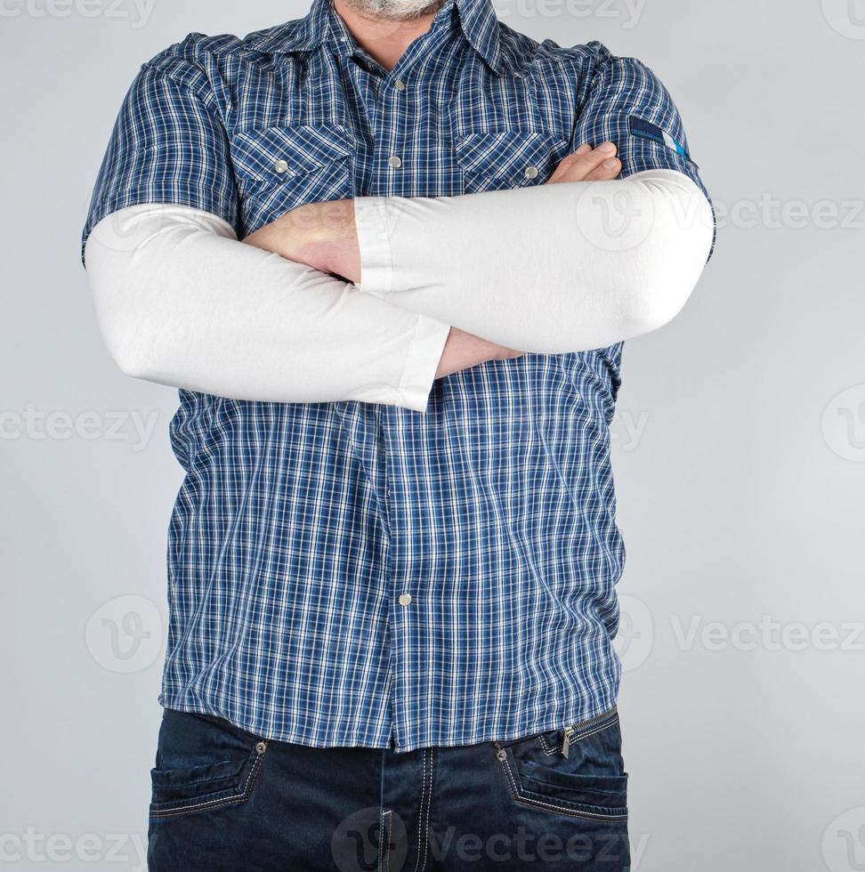 man in a blue plaid shirt and jeans is standing photo