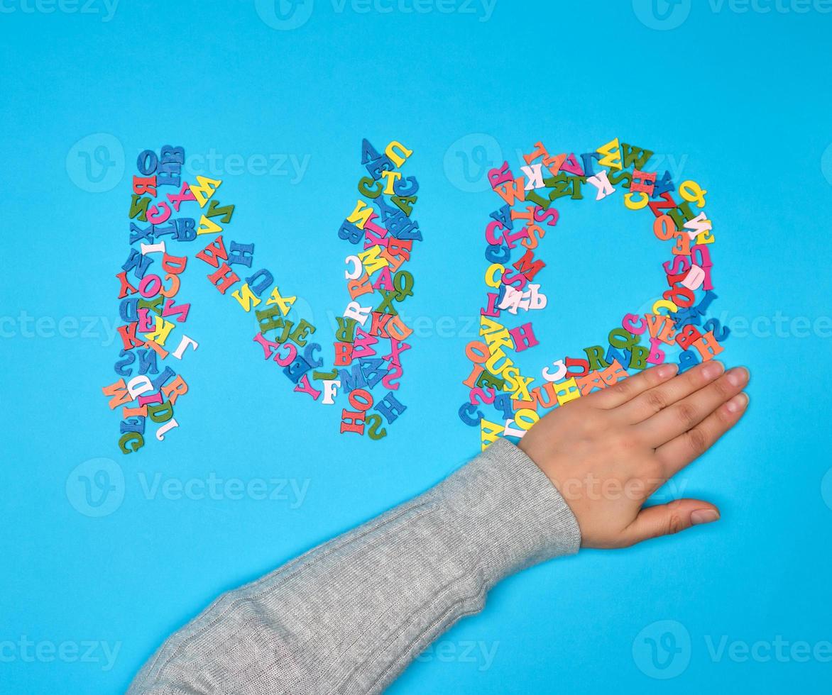 palabra no de pequeñas letras multicolores de madera sobre un fondo azul foto